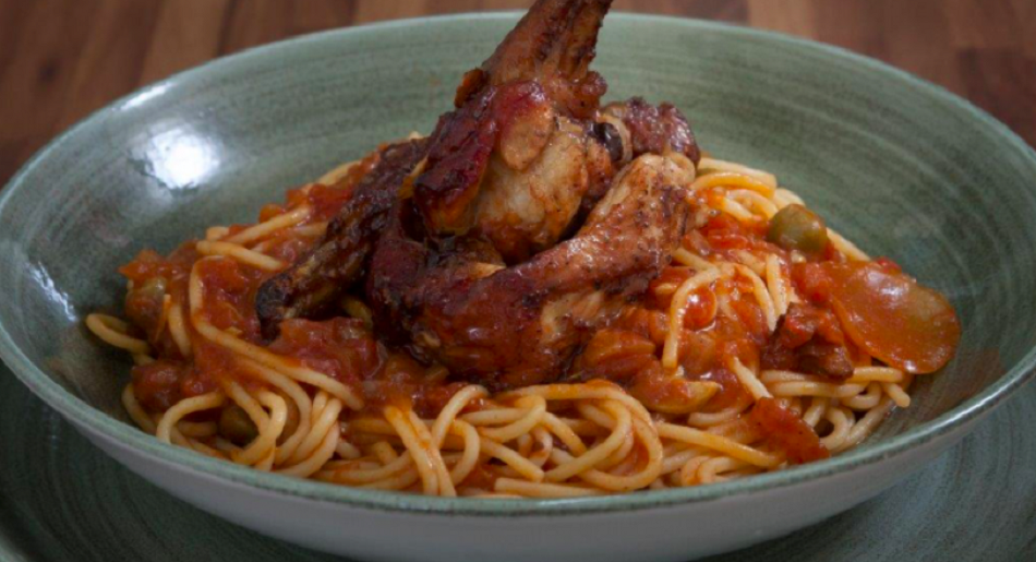 Photo of rabbit stew on a bed of pasta