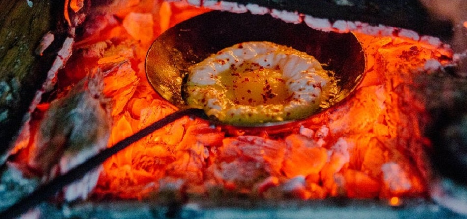 Photo of a special flatz egg maker with egg inside a coal fire pit