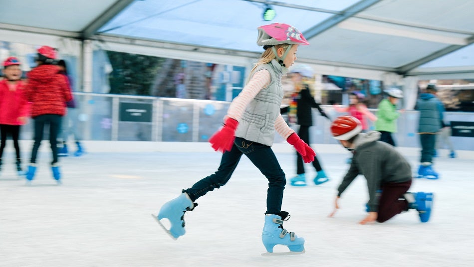 Young girl ice skating on pop up ice rink